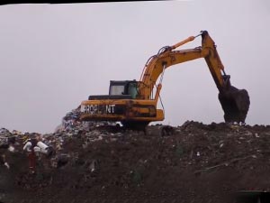 Пересыпка мусора грунтом на полигоне