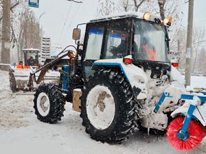 Трактор МТЗ со щёткой убирает снег