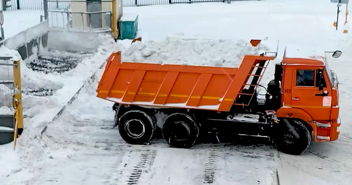 КАМАЗ выгружает снег на снеготаялку в Москве